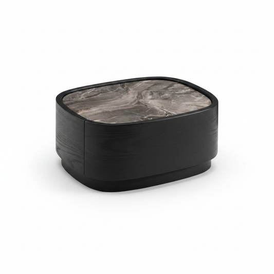 Top view of low rounded matte black bedside table showing dark grey veined marble top