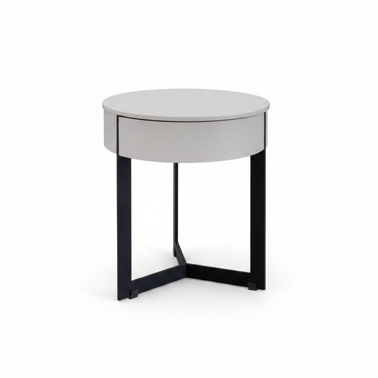 Light grey matte round cylindrical bedside table with one flush drawer on matte black X-cross metal base, front view on white background