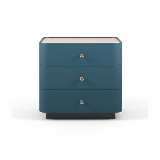 Deep teal upholstered three-drawer bedside table with cream top and silver knob handles on dark plinth base, front view on white background