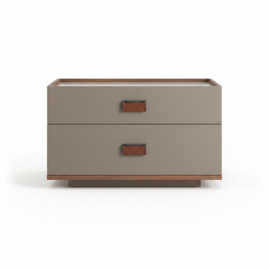 Warm greige matte low two-drawer bedside table with cognac leather pull tab handles on thin walnut plinth base, front view on white background