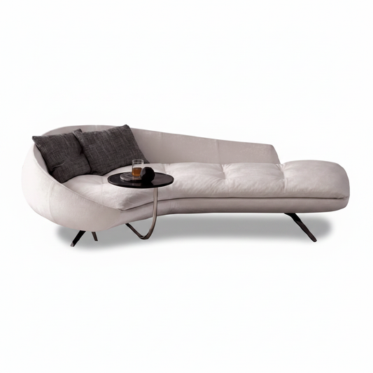 Large curved asymmetric cream fabric chaise sofa with integrated side table and matte black splayed legs on white background