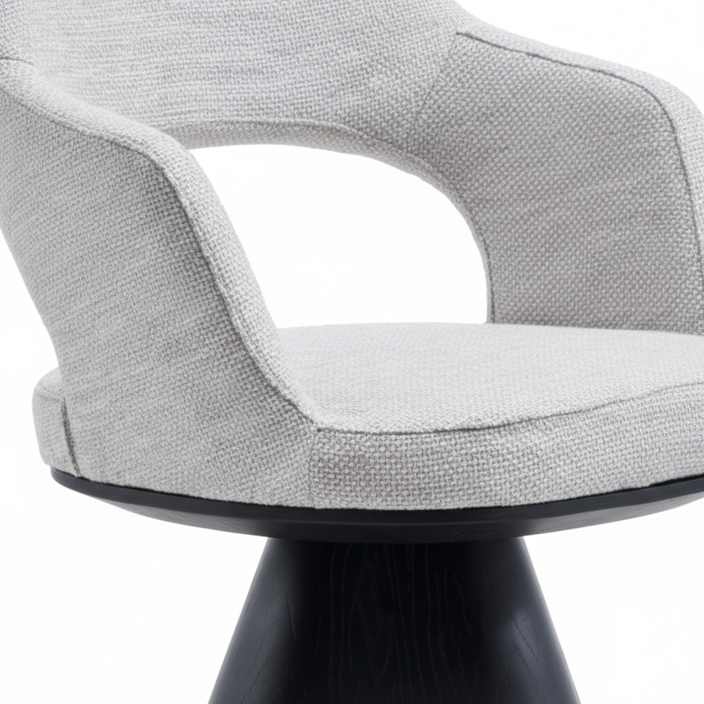 Close-up of the light grey textured fabric upholstery and curved armrest of the Volta Dining Armchair